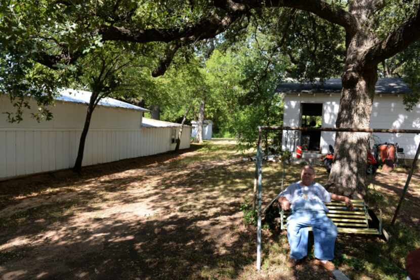 Joe Hardman sits on his backyard swing at his country home on Freeport Parkway, which will...