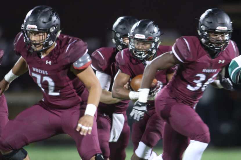 Mansfield Timberview running back Sammy Hicks (22) emerges from the blocks of Charles Roan...