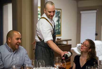 Chef Casey La Rue pours wine for guests Eric Carlos and Ann Davis at a pop-up dinner in Dallas.