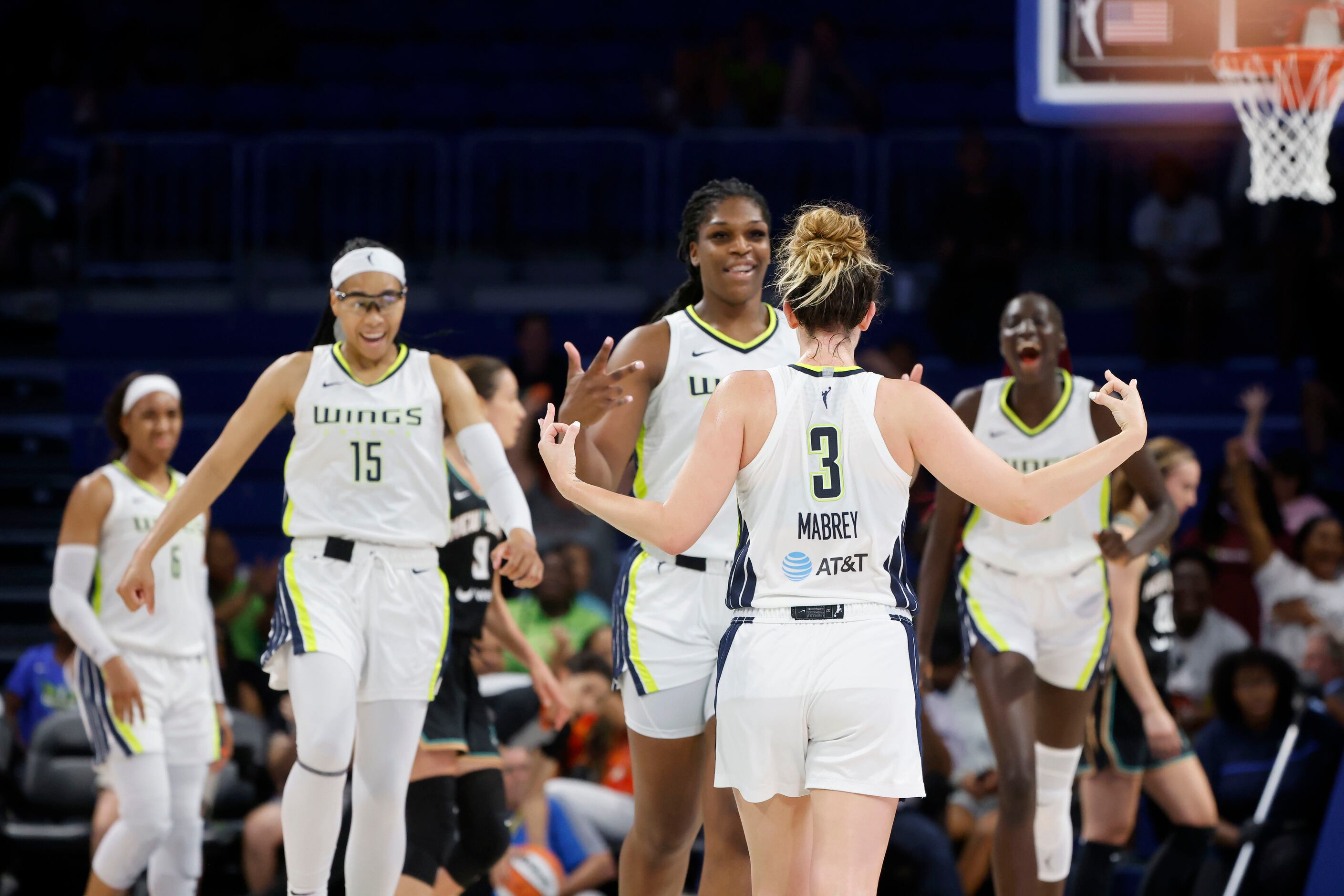 Teammates react after Dallas Wings guard Marina Mabrey (3) made a three-point shot against...