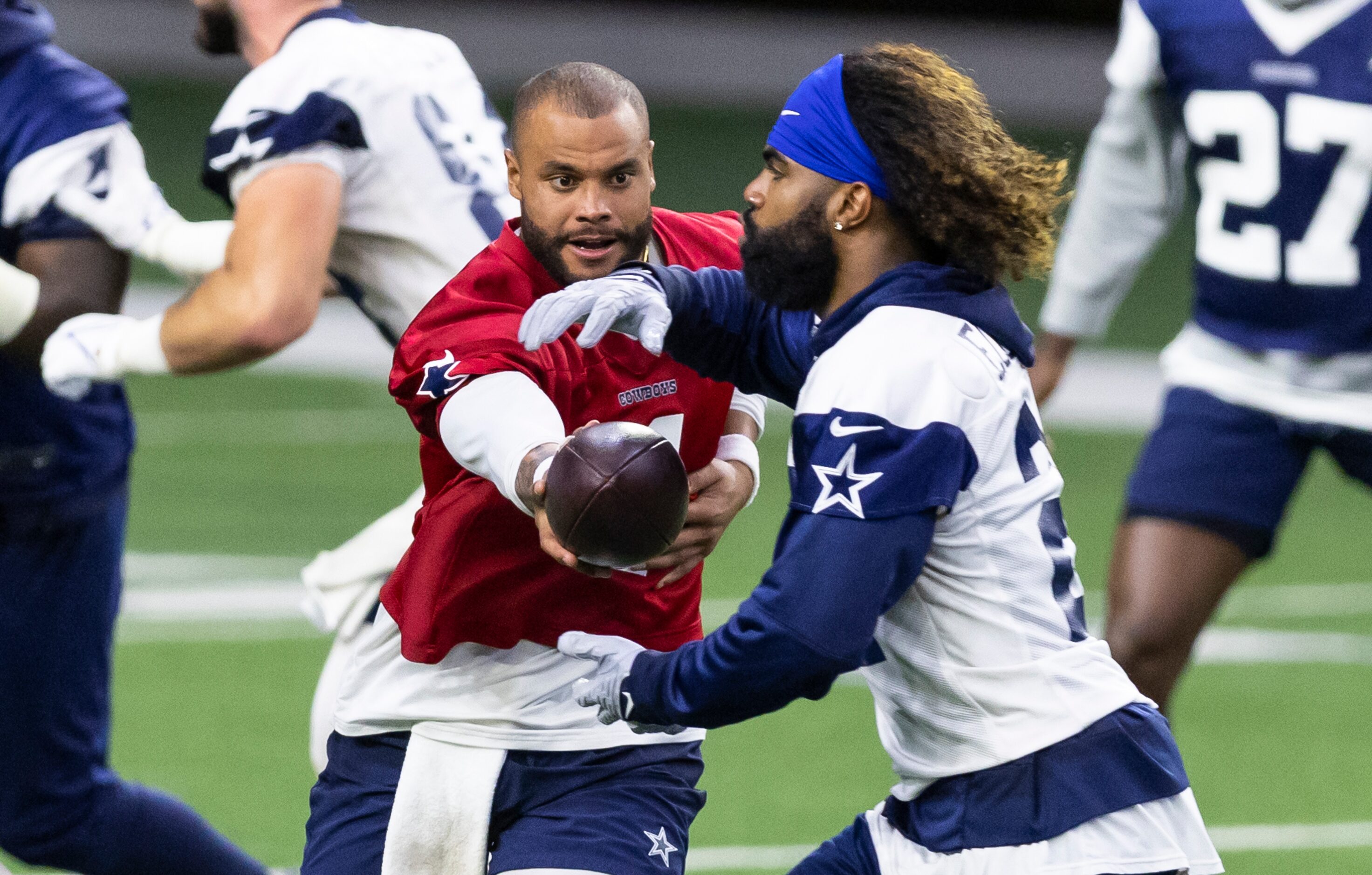 Dallas Cowboys quarterback Dak Prescott hands the ball off to running back Ezekiel Elliott...