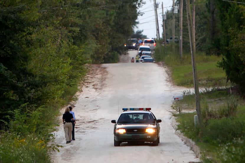 Officials walk along NW 29th Terrace near the scene of a shooting on Thursday in Bell, Fla....
