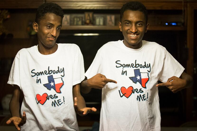 Ethiopian twins, Marcos (right) and Tamirat Bogale show off their T-shirts reading "Somebody...