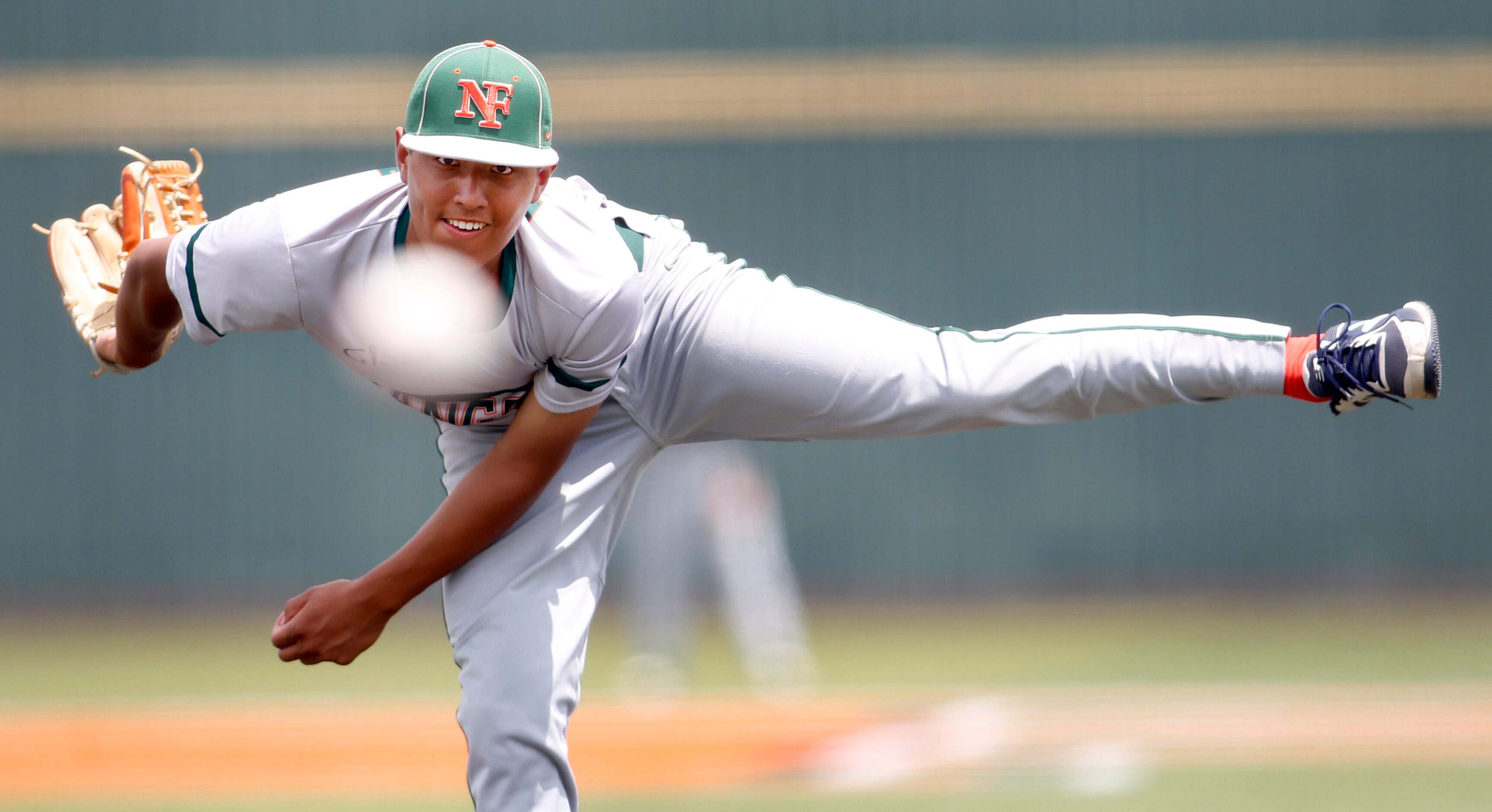 Garland Naaman Forest pitcher Alex Davila (22) follows a pitch to a Rockwall batter during...