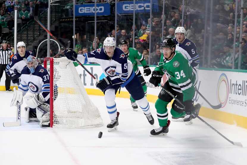 DALLAS, TEXAS - JANUARY 19: Denis Gurianov #34 of the Dallas Stars battles for the puck...