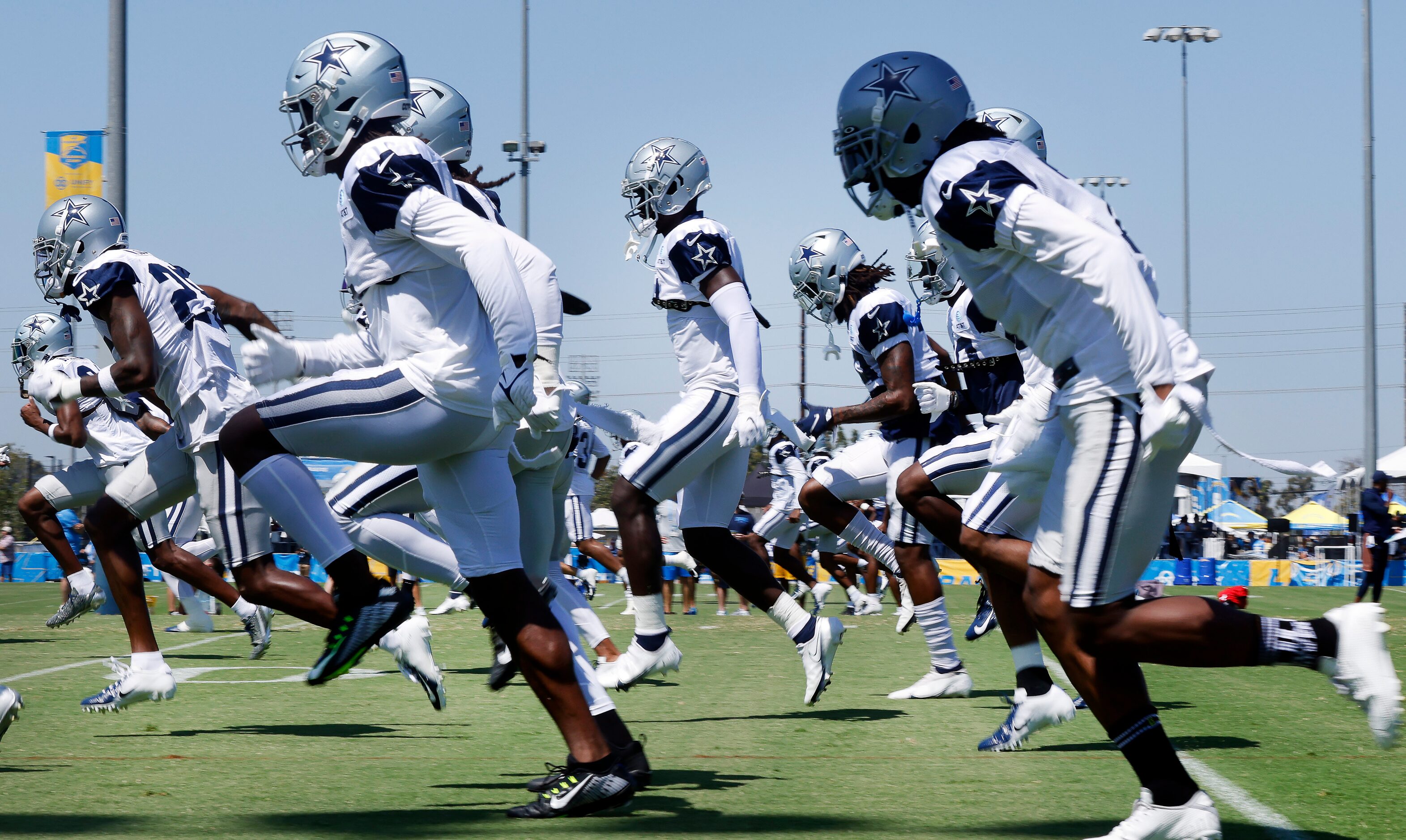 Dallas Cowboys football players warmup before their  joint practice at the Jack Hammett...