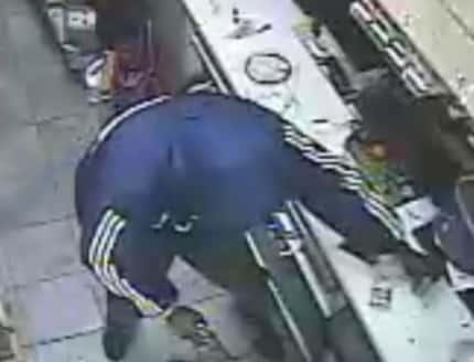 An image from surveillance video shows a man who took part in a robbery and shooting Friday...
