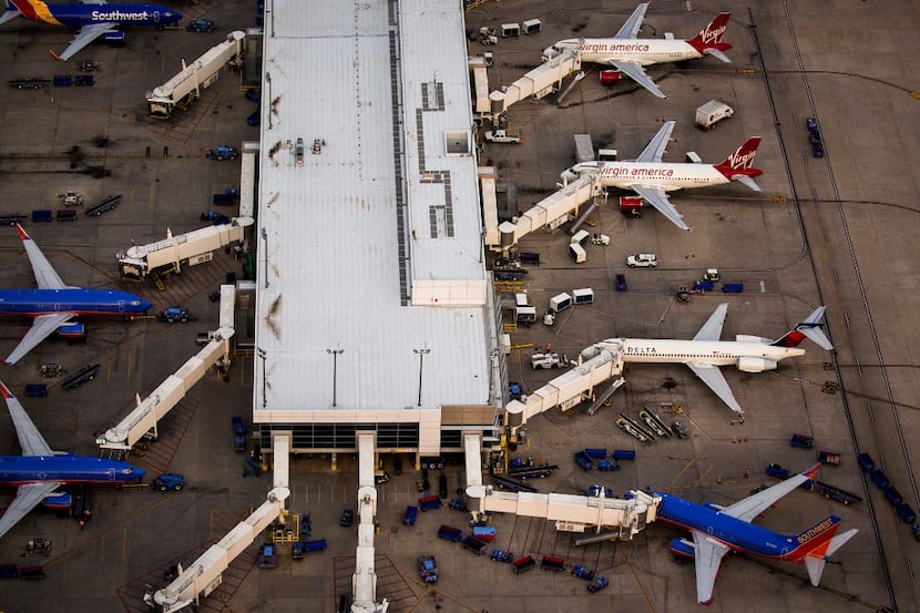 Virgin America, Delta and Southwest airplanes at the gates of Dallas Love Field on Monday,...