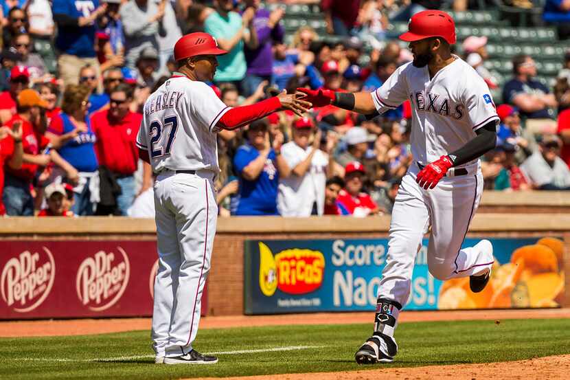 Texas Rangers right fielder Nomar Mazara celebrates with third base coach Tony Beasley as he...