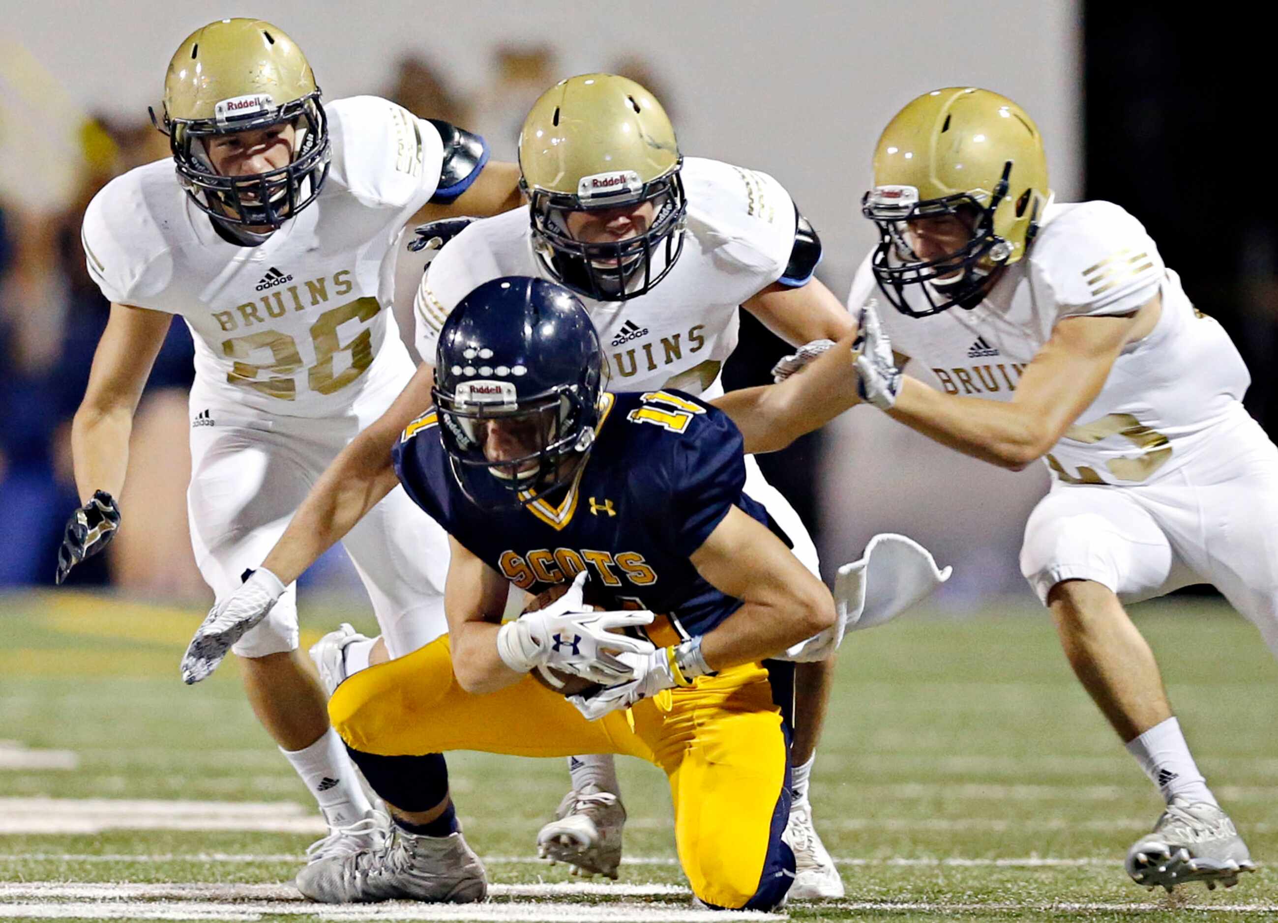 Highland Park's Jeffrey Kupp (11) falls to his knees as he braces for a hit by Pulaski...