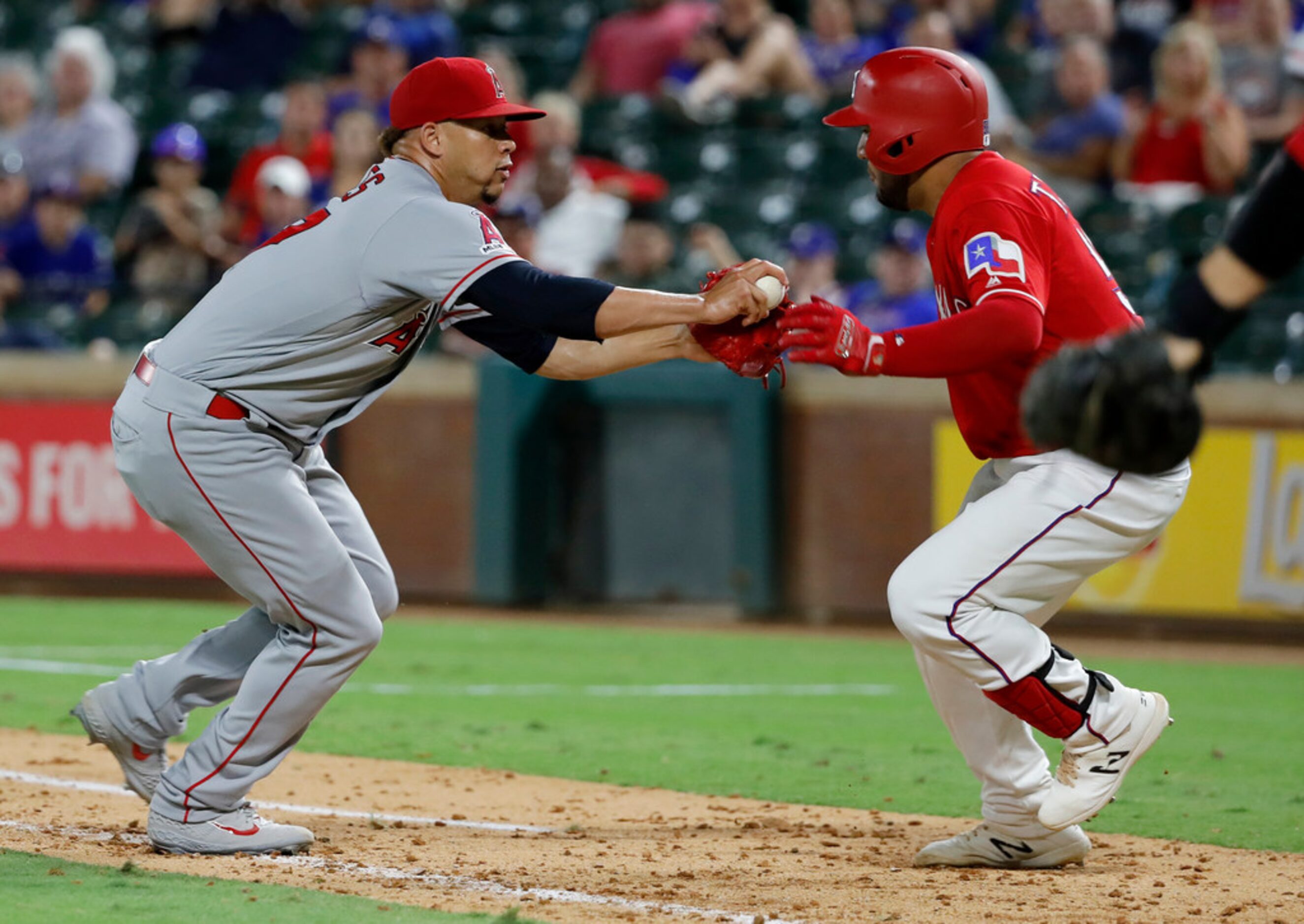 Los Angeles Angels' Hansel Robles tags out Texas Rangers' Jose Trevino down the first base...