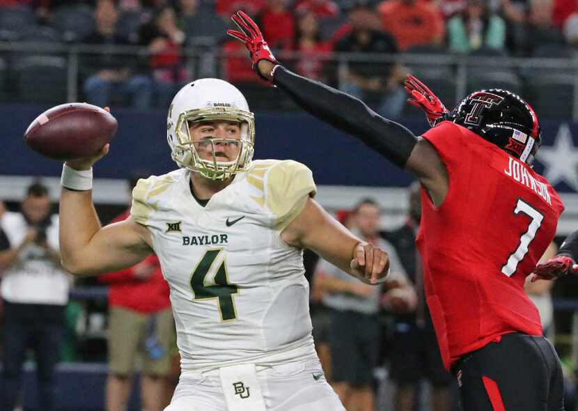 Baylor's Zach Smith (4) gets a pass away under pressure from Texas Tech's Jah'Shawn Johnson...
