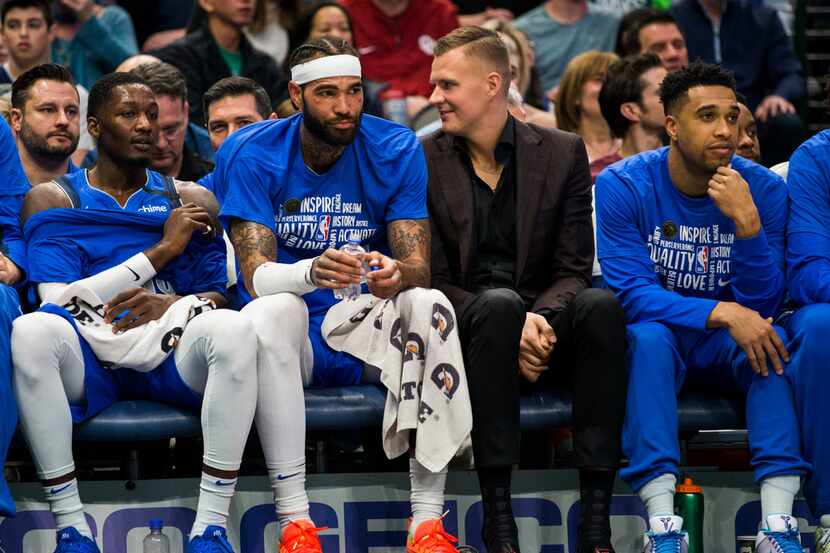 Dallas Mavericks forward Kristaps Porzingis (6) sits on the bench in a suit next to Dallas...