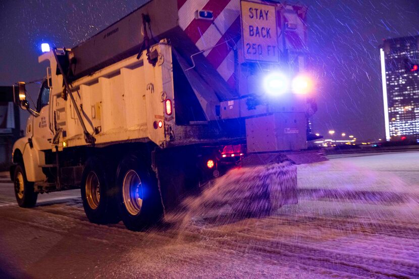 A Texas Department of Transportation truck sands the overpass at N Hall St over North...