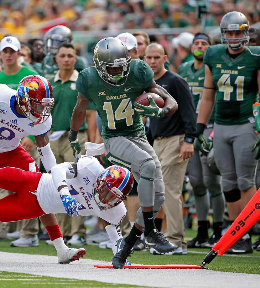 Baylor wide receiver Chris Platt (14) is pushed out of bounds by Kansas linebacker Mike Lee...