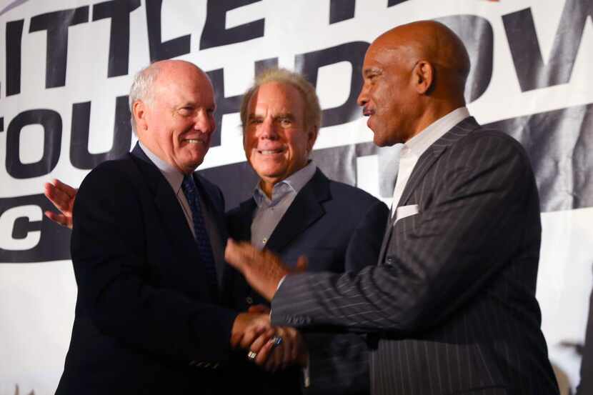 Cliff Harris, left, greets Roger Staubach, center, and Drew Pearson, right, after taking the...
