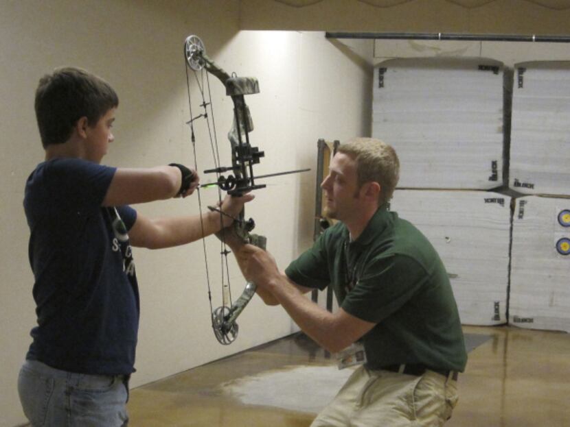 A young archer tries out a new bow at Bass Pro Shops Outdoor World in...
