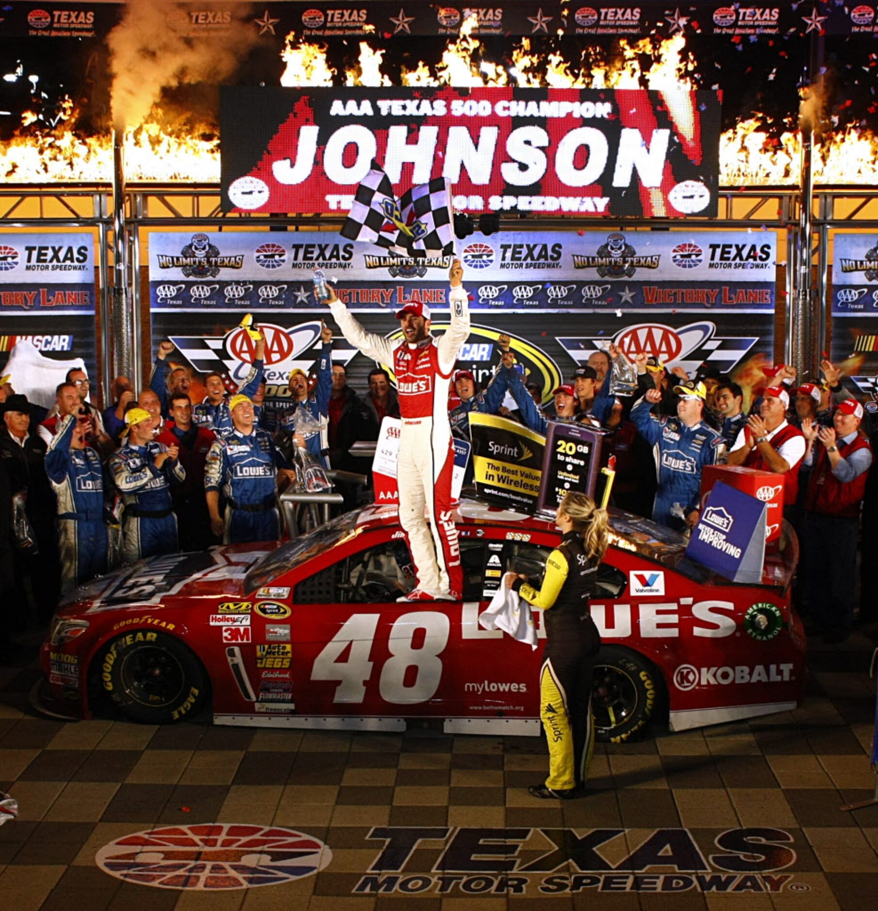 Sprint Cup Series driver Jimmie Johnson (48) stands on his car window and celebrates his AAA...