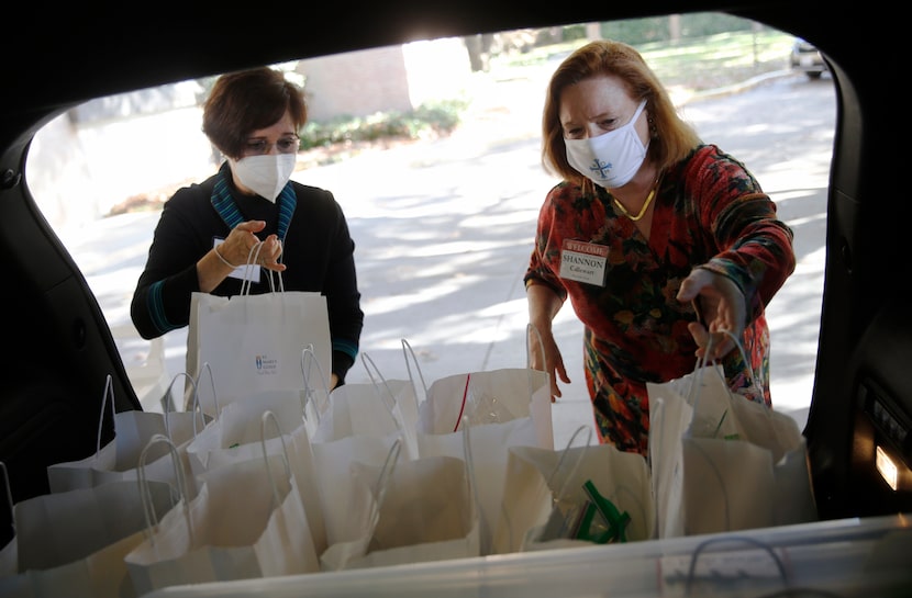 Paula Calise (left) and Shannon Callewart load Shannon's vehicle with baked goods to be...