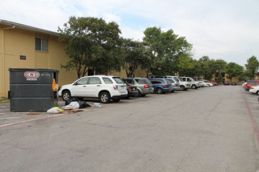 A dumpster overflows with trash at Oak Villas Apartments where Irving code violations...