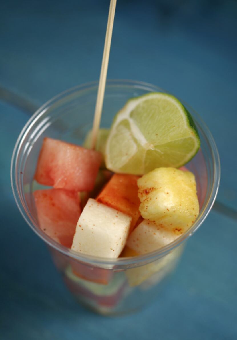 Fruit cups are seasoned with lime juice, salt and pure ground chile.