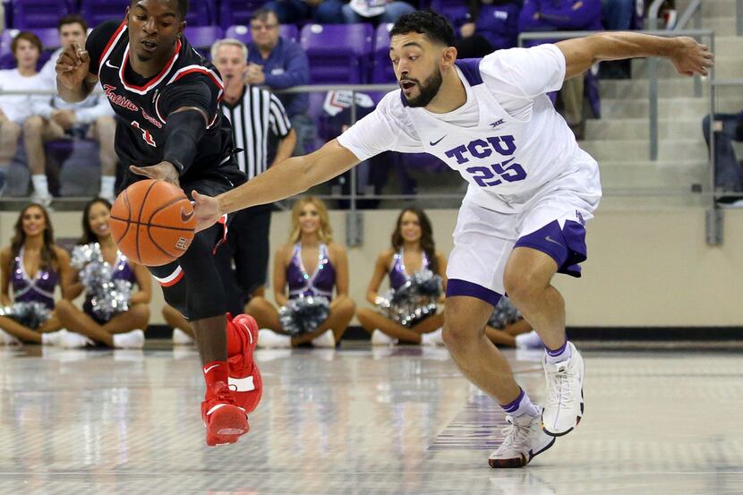 Fresno State guard Braxton Huggins (4) and TCU guard Alex Robinson (25) chase a loose ball...