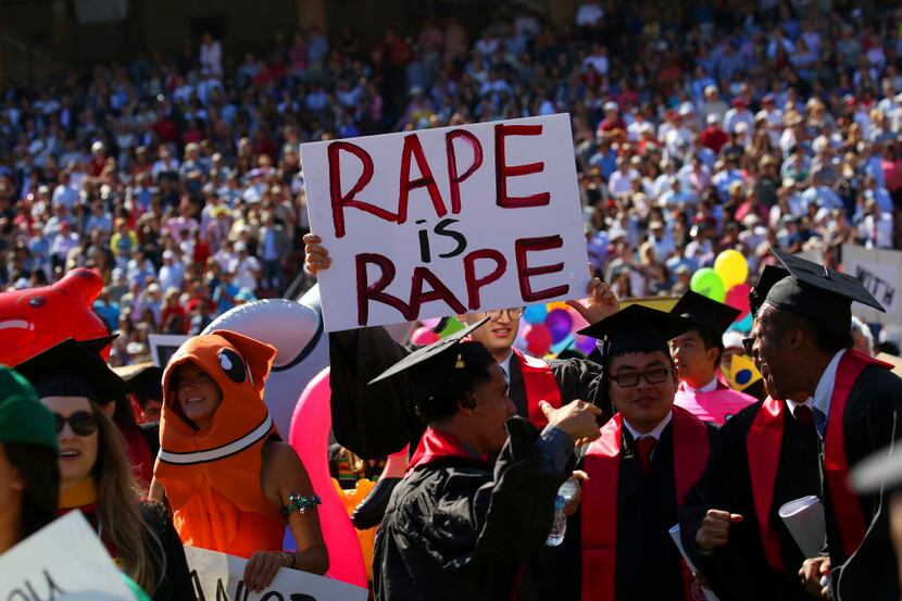 A protest sign in the crowd at Stanfords graduation processional in Stanford, Calif., June...
