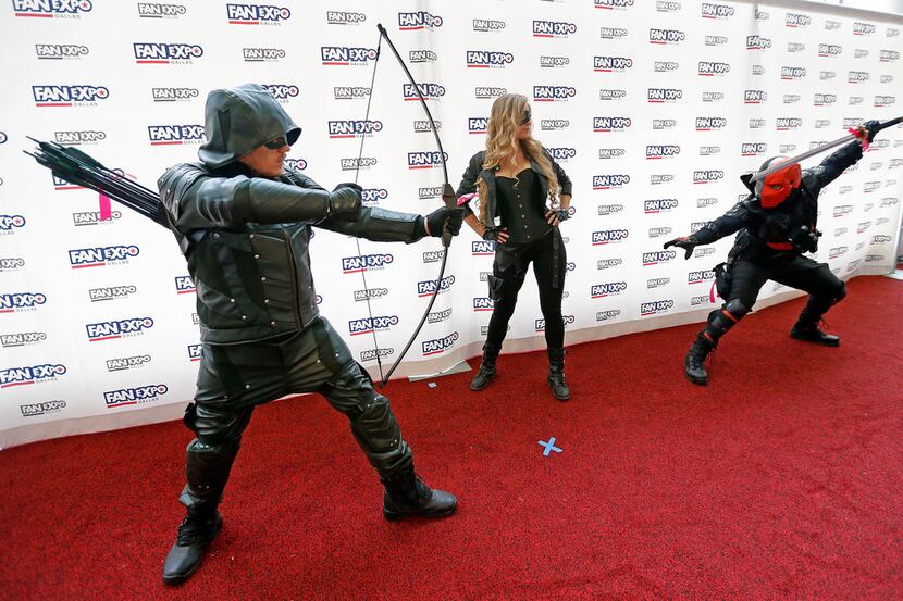 People wearing a costume pose for a photograph at the Cosplay Red Carpet during the FAN EXPO...