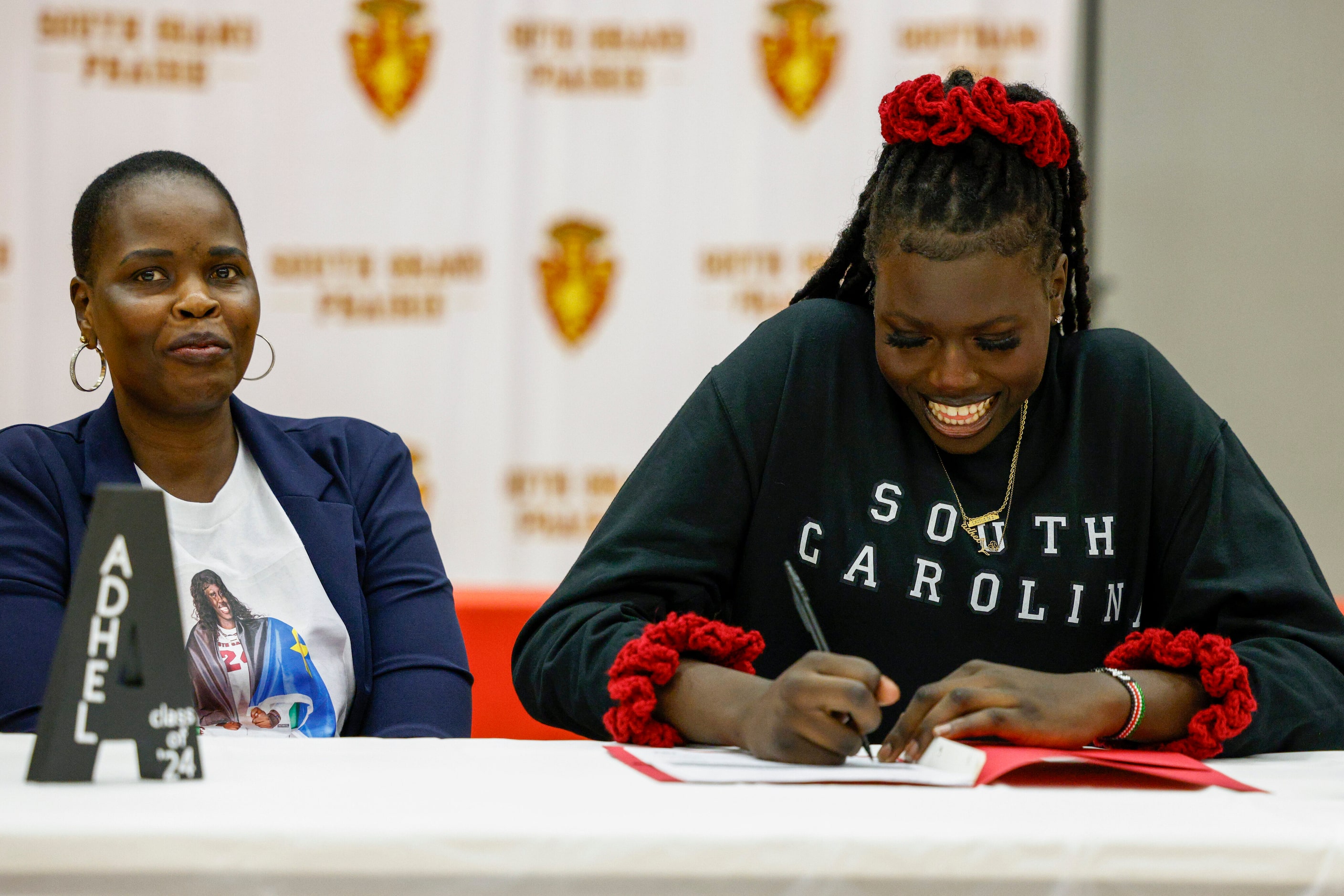 South Grand Prairie girls basketball player Adhel Tac (right) signs alongside her mother...