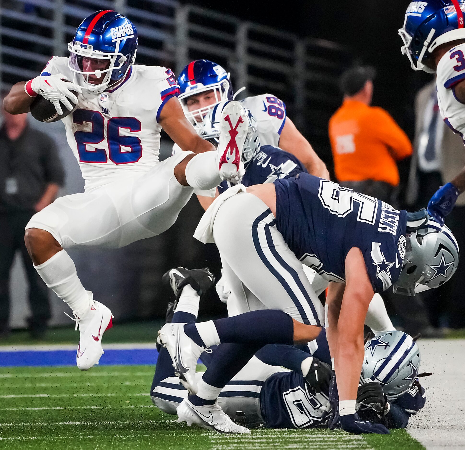 New York Giants running back Saquon Barkley (26) is knocked off his feet by Dallas Cowboys...