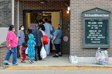 Migrants, who arrived by bus from El Paso, walk into Oak Lawn United Methodist Church in...
