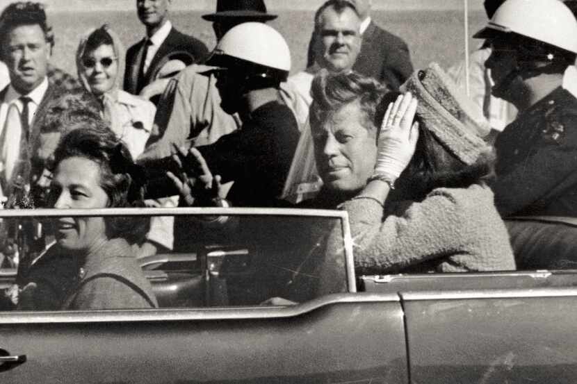 In this Nov. 22, 1963 photo, President John F. Kennedy waves from his car in a motorcade...