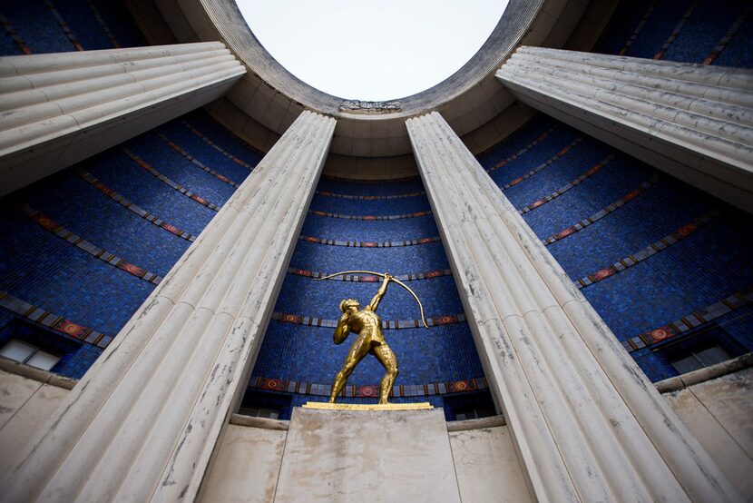 A gold leaf statue of a Tejas Indian is paired with original blue tiles outside the historic...