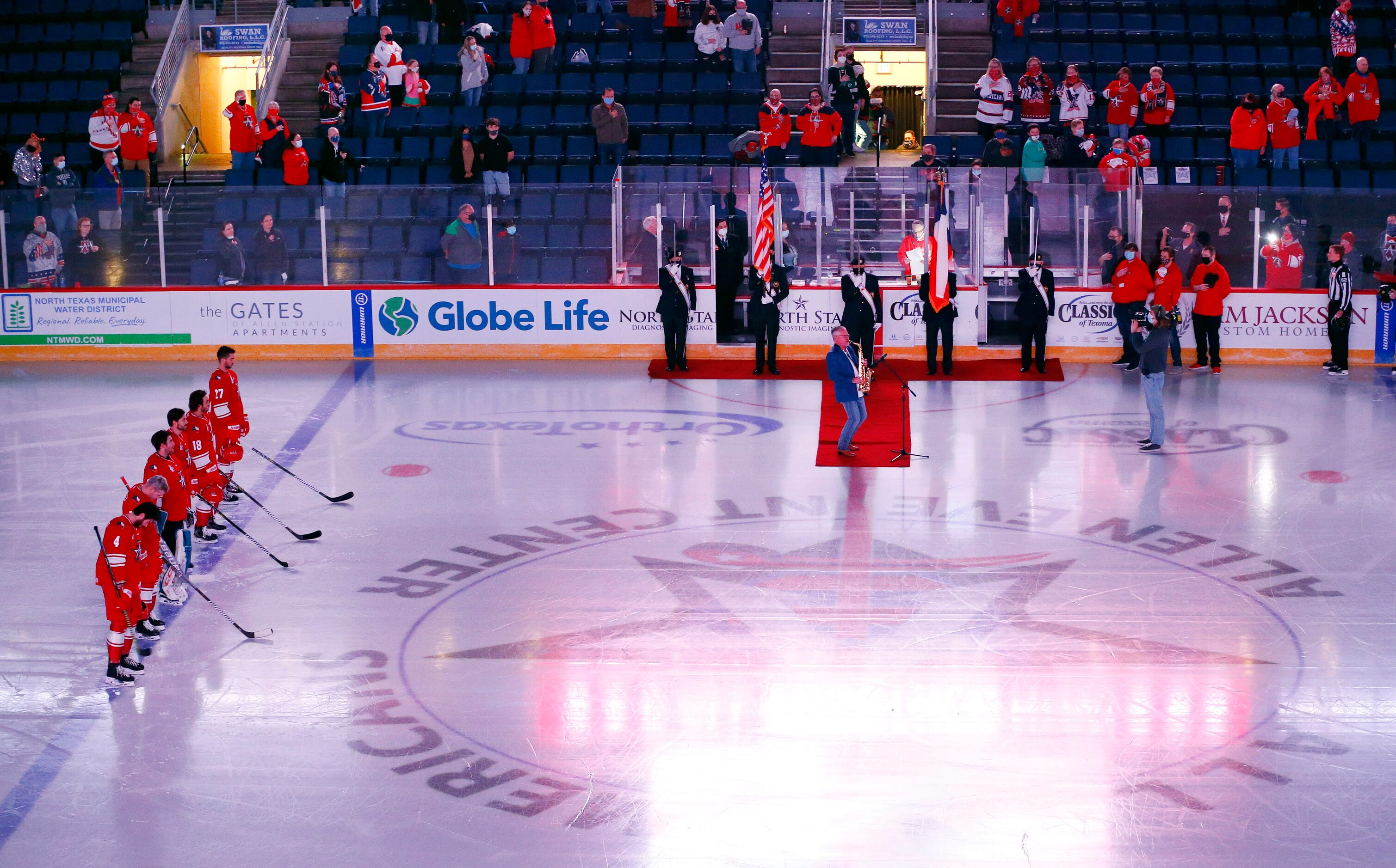 The Allen Americans hockey players line up for the national anthem played by a saxophonist...