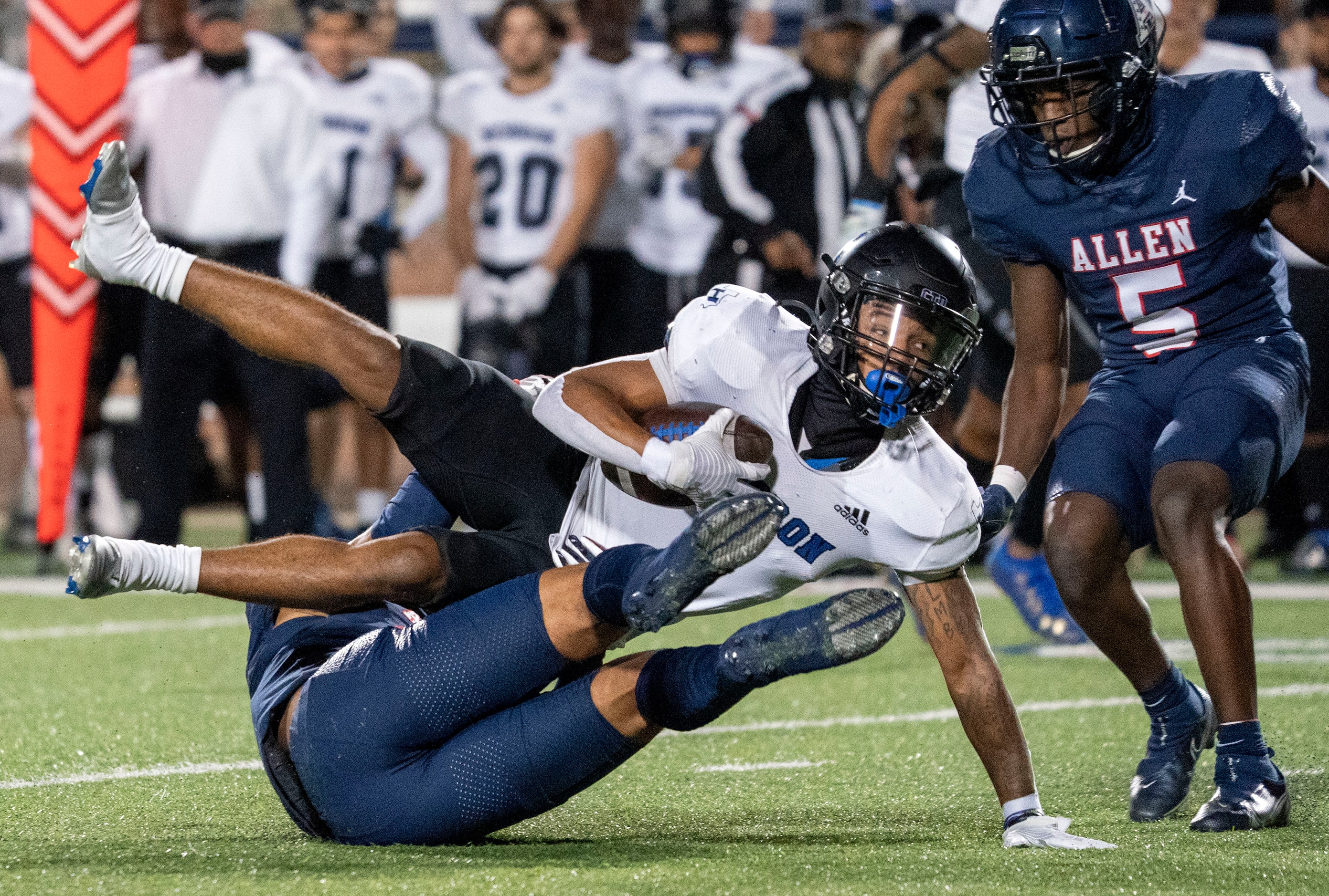 Hebron wide receiver Takoda Bridges (1) rolls over Allen junior defensive back Malakai...