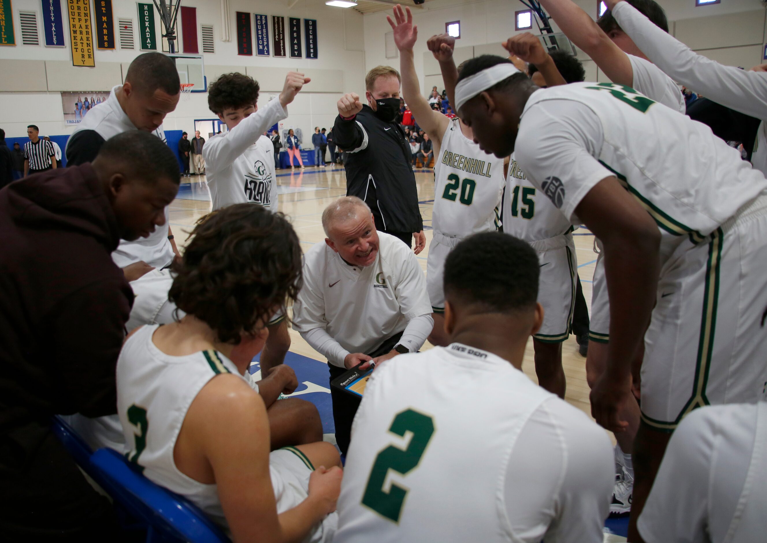 Greenhill head coach Joey Sims, center, diagrams a play for his players during a 4th quarter...