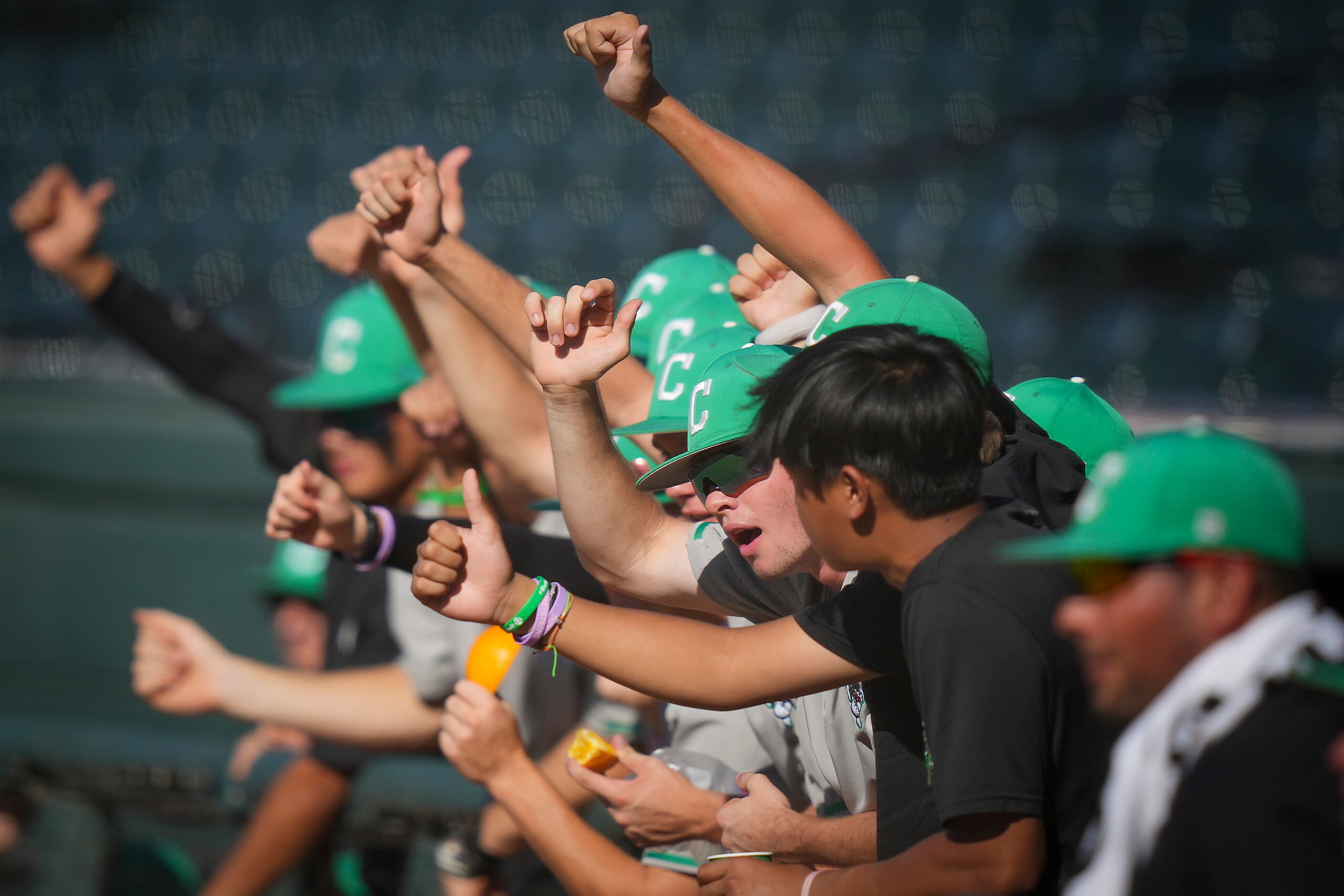 Players in the Southlake Carroll dugout celebrate a strikeout by pitcher Griffin Herring...