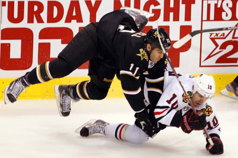 Centers Jake Dowell (11) of the Stars and Patrick Sharp of the Chicago Blackhawks collide at...