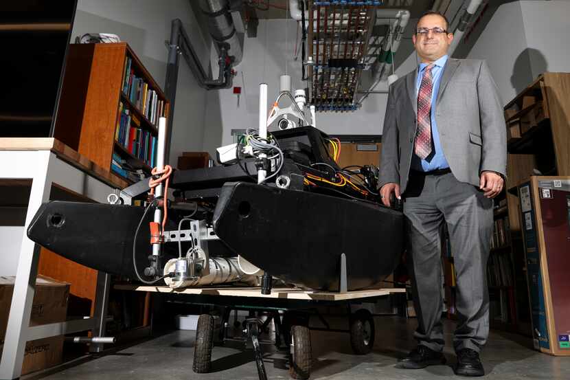 Dr. David Lary, Professor of Physics, stands next to an autonomous boat Tuesday, July 5,...