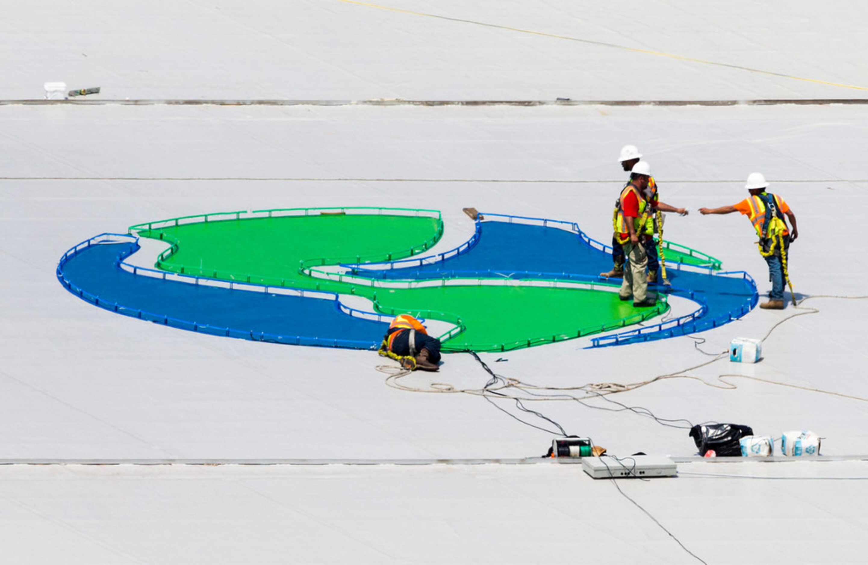 Crews work on a Globe Life Field logo on the roof of the stadium during an open house for...