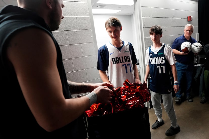 Dallas Mavericks guard Luka Doncic presents gifts to Make-A-Wish participant Thomas Marshall...