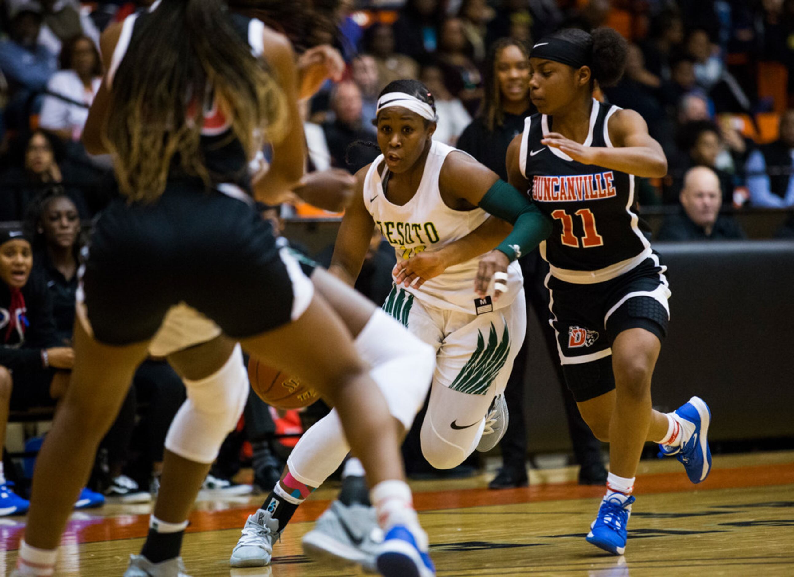 DeSoto's Michayla Gatewood (15) takes the ball past Duncanville's Tristen Taylor (11) during...