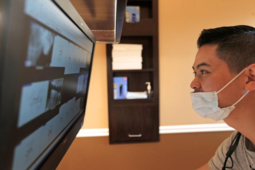 
Dr. Do reviews dental X-rays taken of Johnson during Smiles Giving Day.
