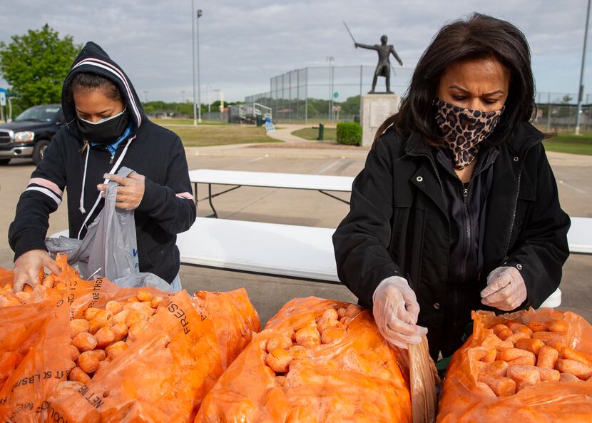 Abby Hernandez, left, and Dolores Dominguez help prepare food to be distributed with the...