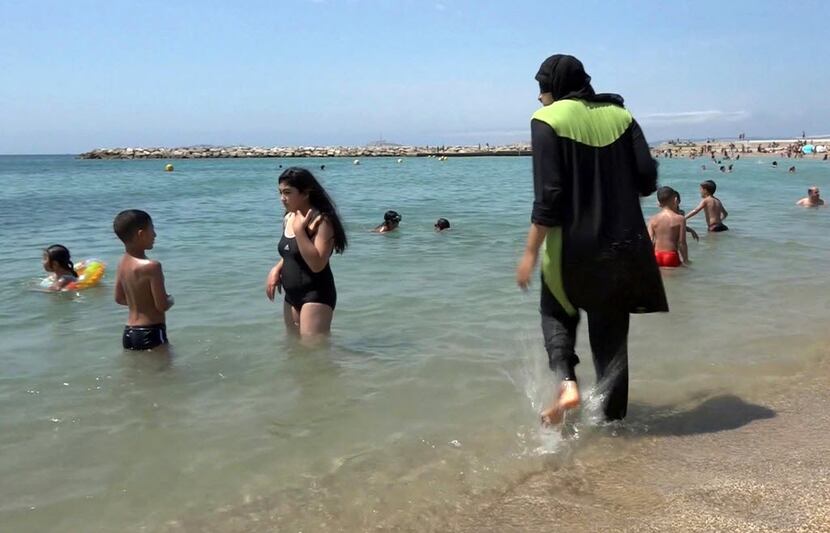 Nissrine Samali, 20, gets into the sea wearing a burkini, a wetsuit-like garment that also...