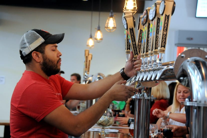Quin Tinling pours beer for guests at Lakewood Brewing Company's grand opening of the...