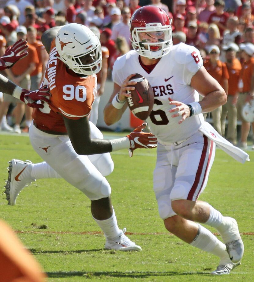 Oklahoma Sooners quarterback Baker Mayfield (6) looks for a receiver as he avoids Texas...