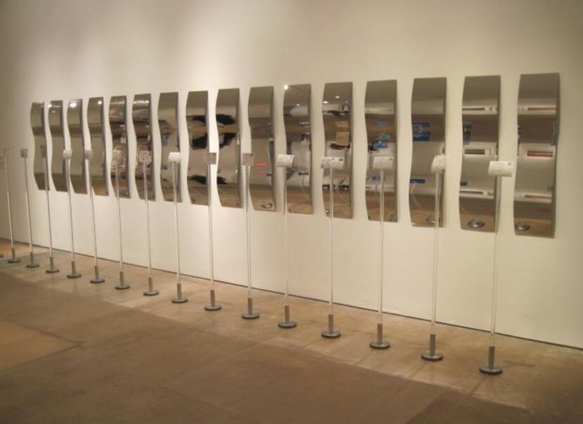 
The title of Daniel Joseph Martinez’s lineup of postcards, reflected in wavy mirrors,...