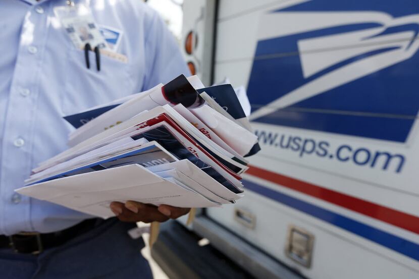  A postal worker delivers mail in Dallas. (DMN file photo)