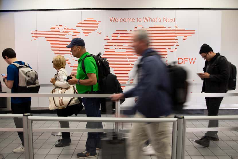 Passengers waited to pass through security during a busy day at DFW International Airport on...